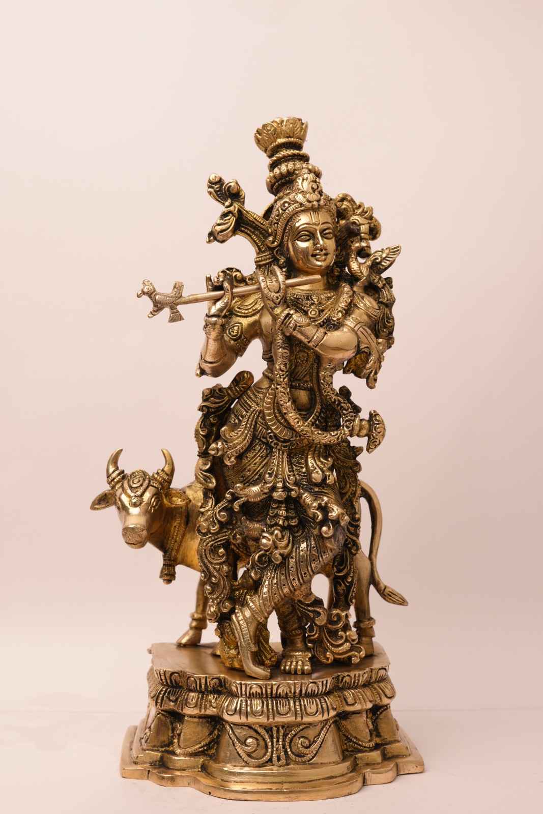 Bronze statue of a deity with a bull on a light pink background